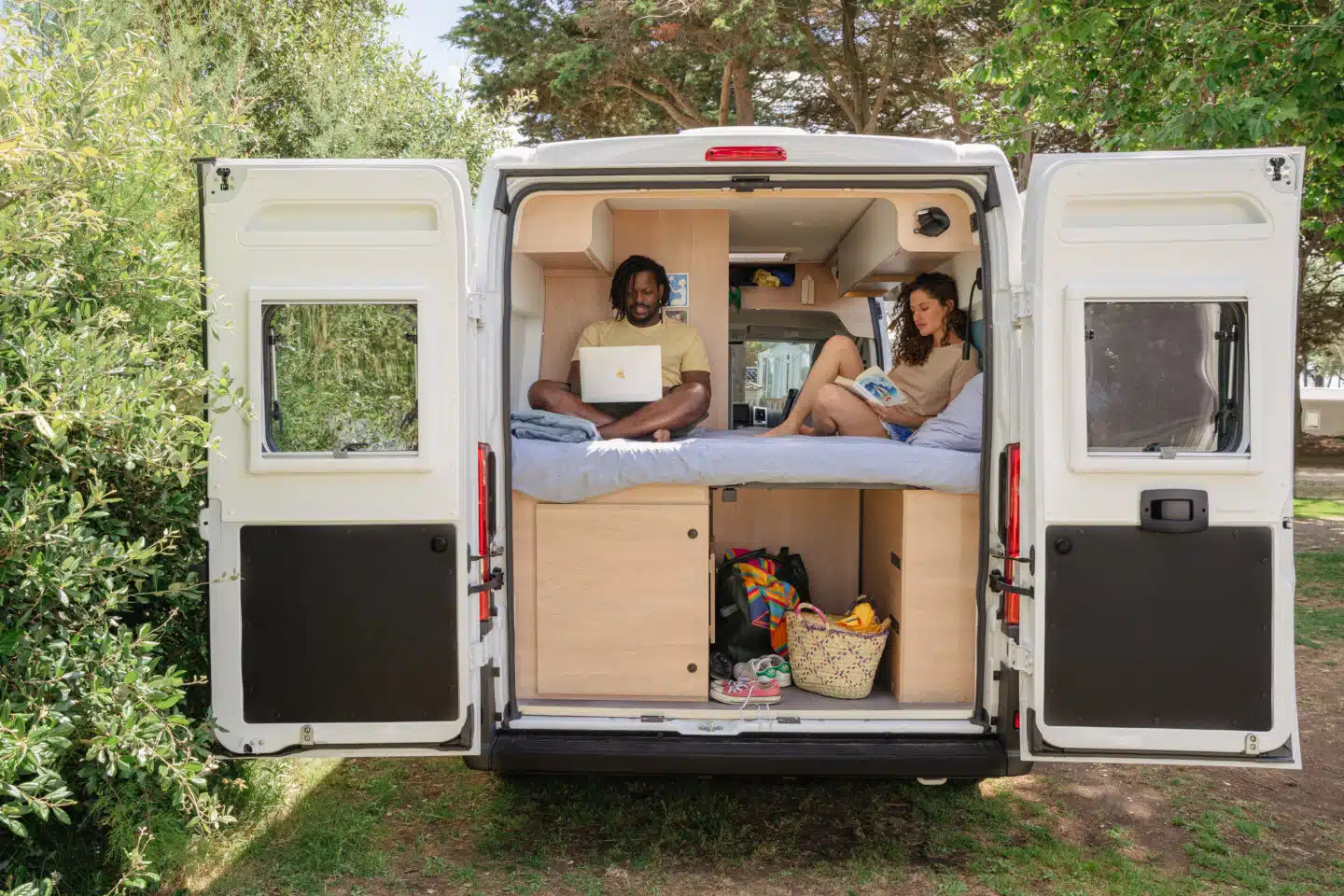 Couple en train de lire dans un fourgon aménagé Joa Camp